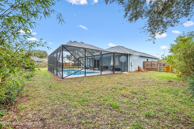 rear view of property featuring a yard, a lanai, and a patio area