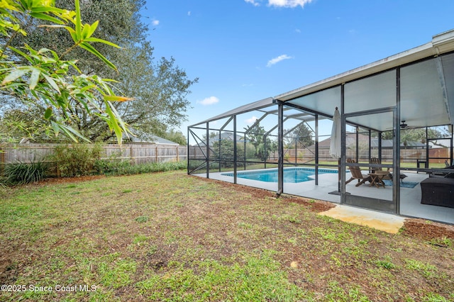 view of yard featuring a fenced in pool, a patio, and glass enclosure