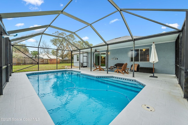 view of swimming pool featuring a patio area, a lawn, and glass enclosure