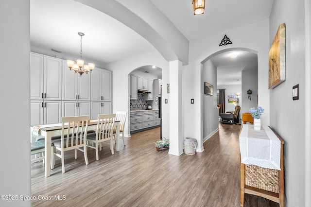 dining area with hardwood / wood-style flooring and a chandelier