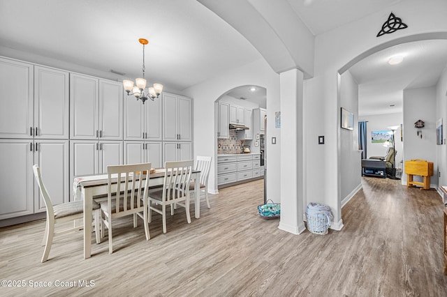 dining space featuring an inviting chandelier and light hardwood / wood-style flooring