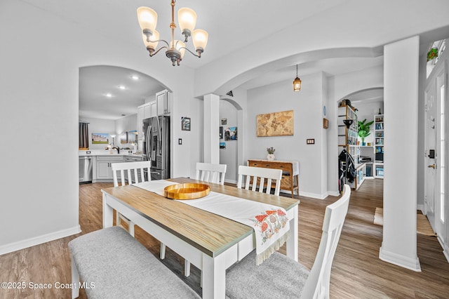 dining space with a notable chandelier and light wood-type flooring