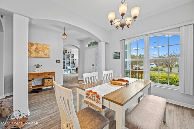 dining area featuring hardwood / wood-style floors, a notable chandelier, and a healthy amount of sunlight