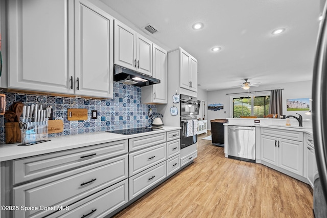 kitchen featuring white cabinetry, light wood-type flooring, sink, and black appliances