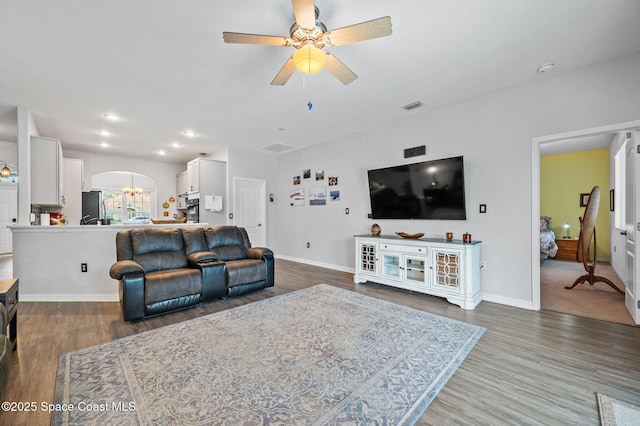 living room featuring dark hardwood / wood-style floors and ceiling fan with notable chandelier