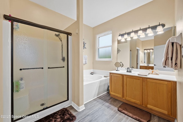 bathroom with hardwood / wood-style flooring, vanity, and separate shower and tub