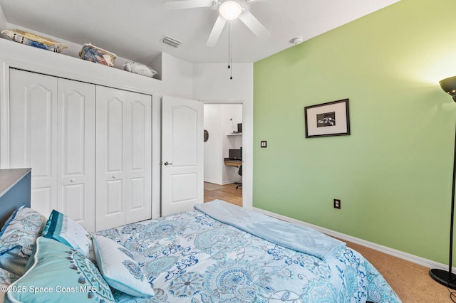 bedroom featuring ceiling fan, light carpet, and a closet