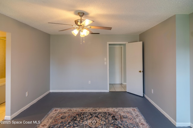 spare room featuring ceiling fan, concrete flooring, and a textured ceiling