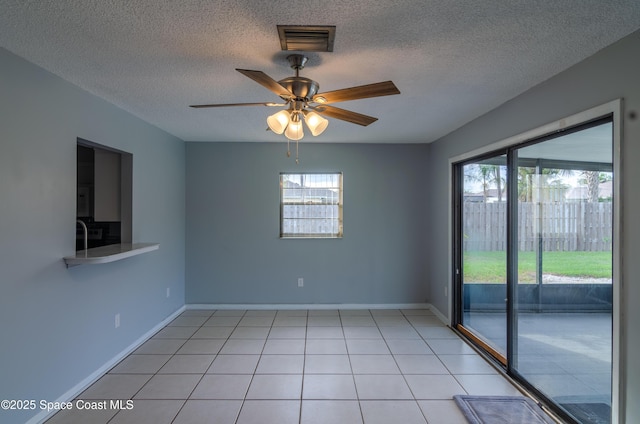 tiled spare room featuring ceiling fan and a textured ceiling