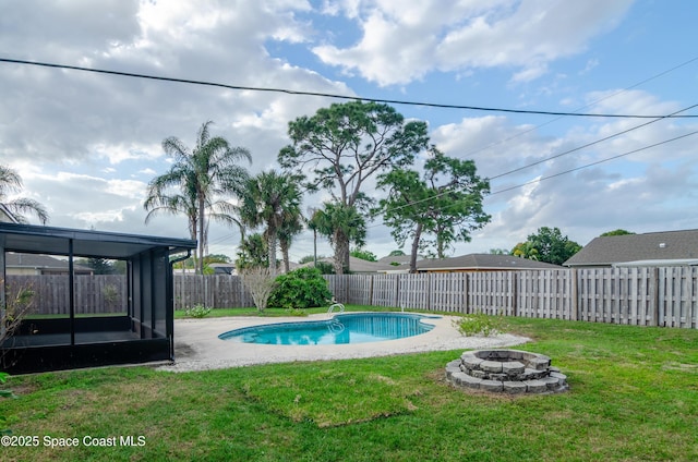 view of pool with an outdoor fire pit, a sunroom, and a lawn