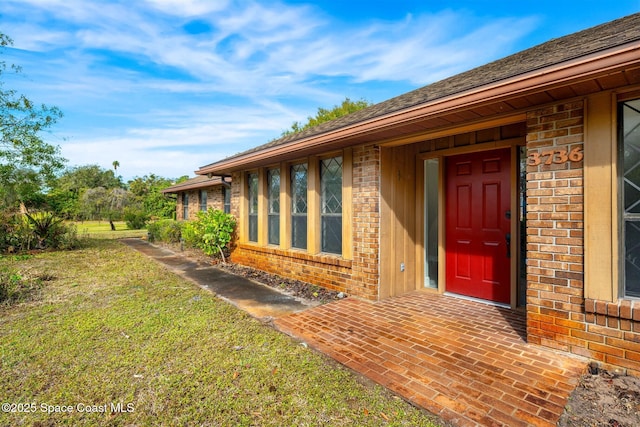 view of exterior entry with a lawn