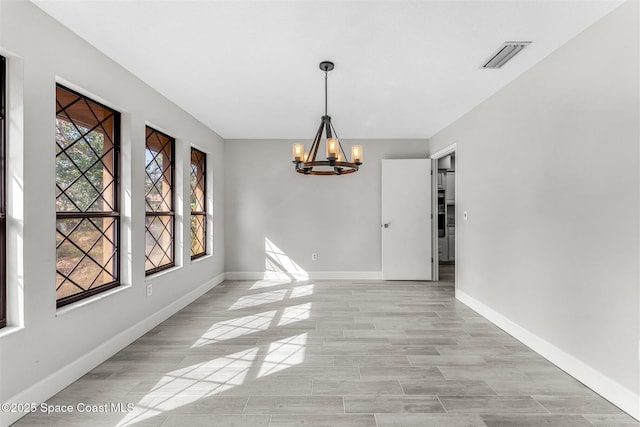 unfurnished dining area featuring a notable chandelier