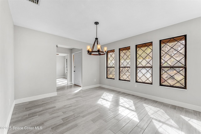 unfurnished dining area with a notable chandelier