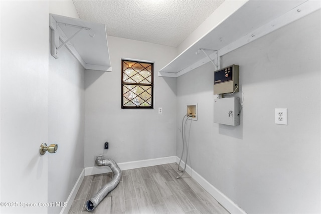 washroom with hookup for a washing machine, a textured ceiling, and light hardwood / wood-style floors