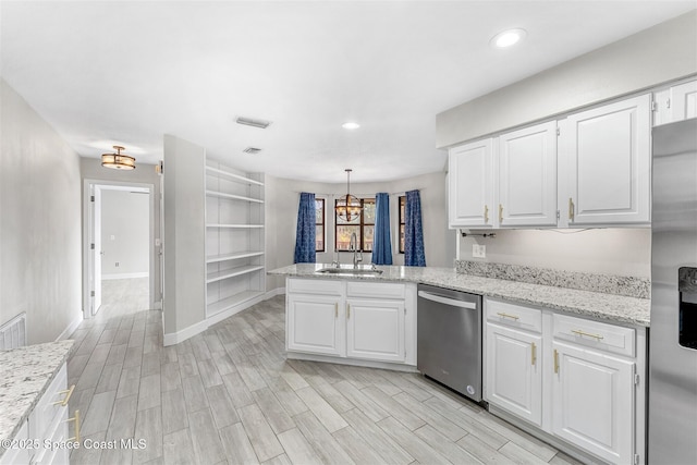 kitchen featuring white cabinetry, sink, pendant lighting, and appliances with stainless steel finishes