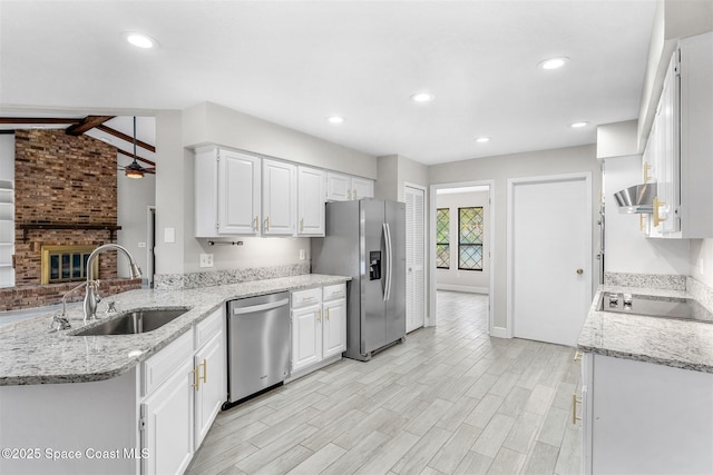 kitchen featuring light stone counters, stainless steel appliances, sink, and white cabinets