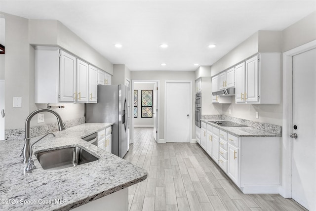 kitchen featuring light stone counters, sink, white cabinets, and appliances with stainless steel finishes