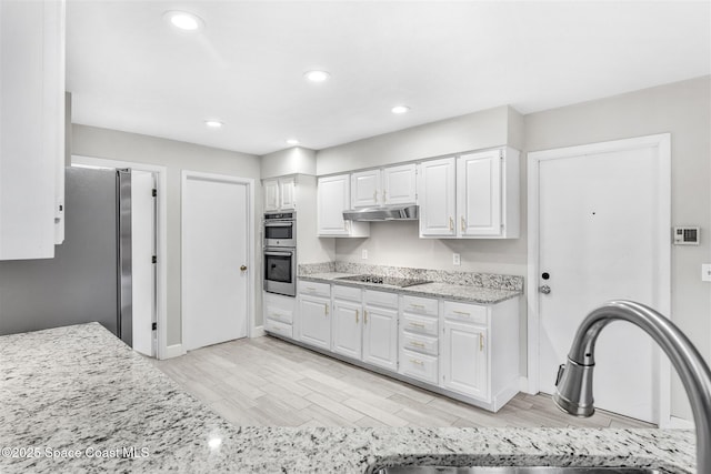 kitchen featuring white cabinetry, sink, light stone counters, light hardwood / wood-style floors, and stainless steel appliances