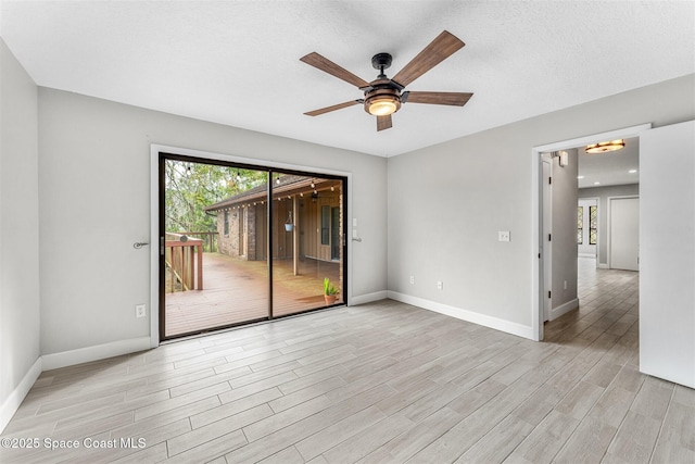 spare room featuring ceiling fan, a textured ceiling, and light wood-type flooring