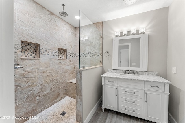 bathroom with vanity and tiled shower