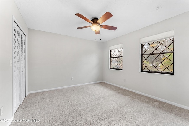 unfurnished bedroom with a closet, ceiling fan, and carpet flooring