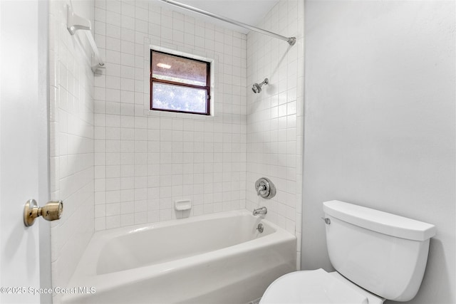 bathroom featuring tiled shower / bath and toilet