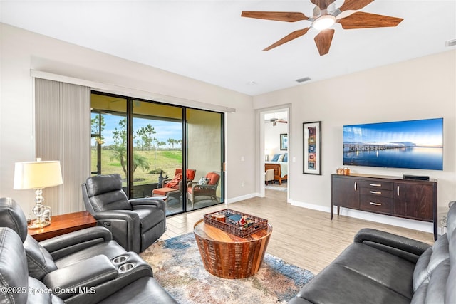 living room with ceiling fan and light hardwood / wood-style flooring