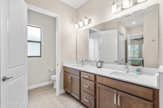 bathroom with vanity, ceiling fan, and toilet