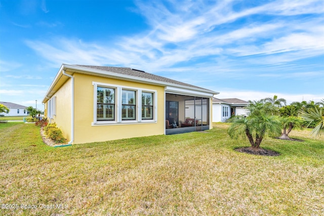 back of house with a sunroom and a yard