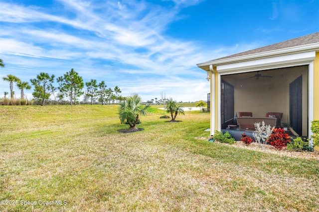 view of yard with a sunroom and ceiling fan