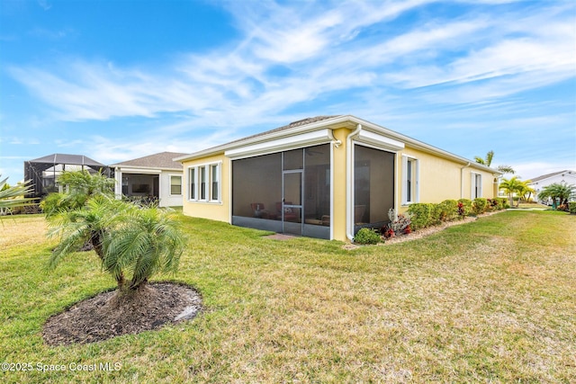 rear view of property featuring a sunroom and a yard