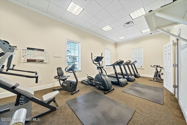 gym with crown molding and a drop ceiling