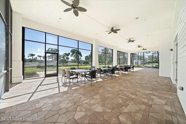 unfurnished sunroom with a wealth of natural light and ceiling fan