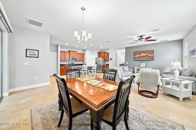 tiled dining room featuring ceiling fan with notable chandelier