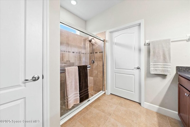 bathroom featuring vanity and a shower with door