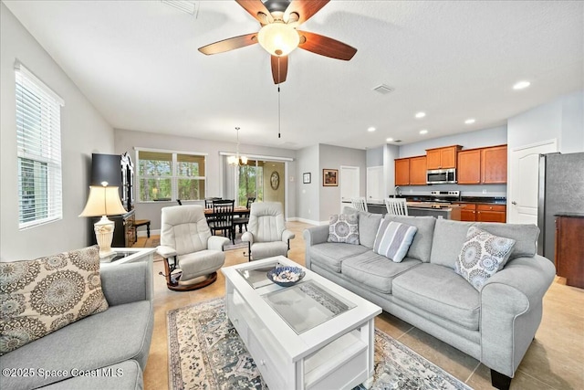 living room with ceiling fan with notable chandelier