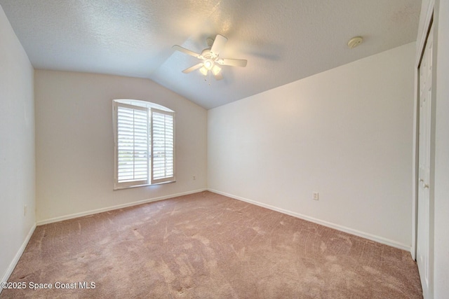 carpeted spare room with ceiling fan, lofted ceiling, and a textured ceiling