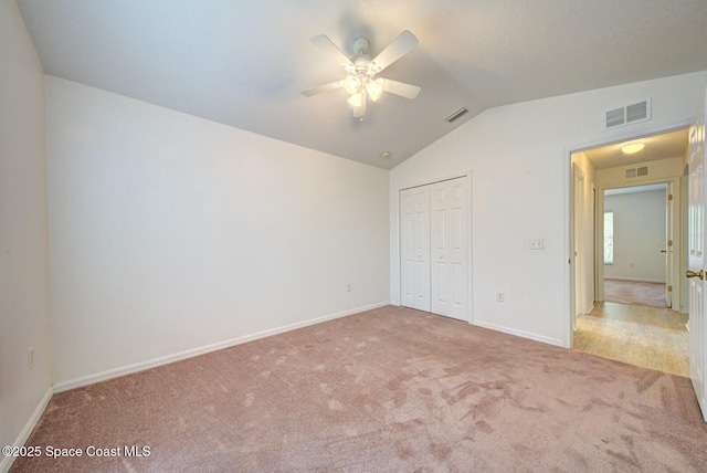 unfurnished bedroom with ceiling fan, lofted ceiling, carpet flooring, and a closet