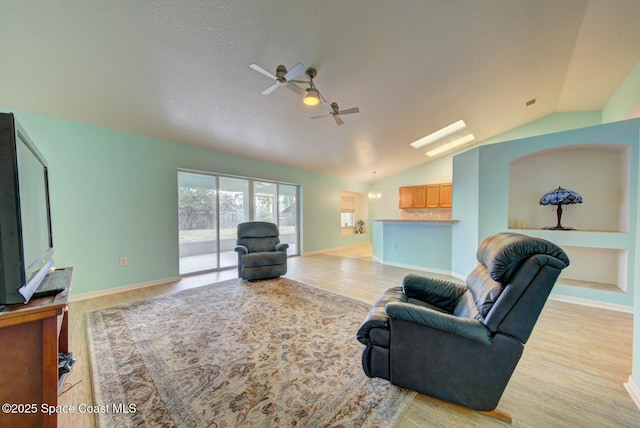 living room featuring vaulted ceiling, ceiling fan, and light wood-type flooring