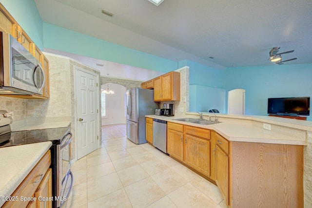 kitchen with sink, tasteful backsplash, a chandelier, light tile patterned floors, and stainless steel appliances