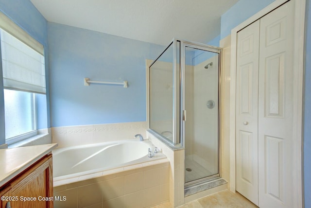 bathroom with tile patterned flooring, vanity, and separate shower and tub