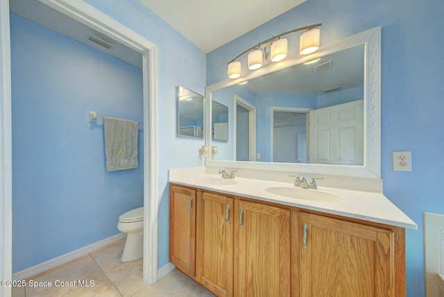 bathroom featuring tile patterned flooring, vanity, and toilet