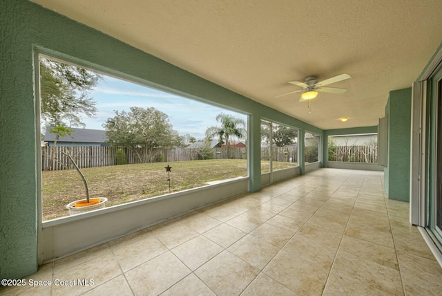 unfurnished sunroom with ceiling fan