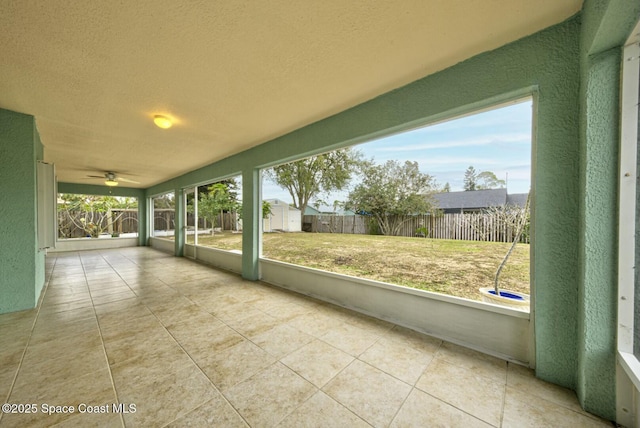 unfurnished sunroom featuring ceiling fan