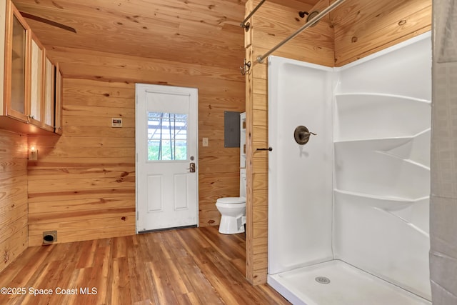 bathroom with hardwood / wood-style flooring, walk in shower, toilet, and wood walls