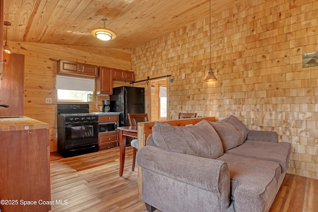 living room featuring light hardwood / wood-style flooring, vaulted ceiling, wooden ceiling, and a barn door