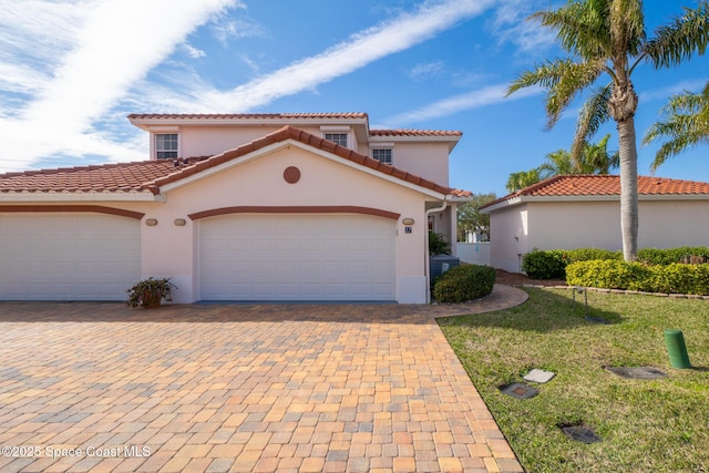 mediterranean / spanish-style house featuring a garage and a front yard