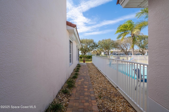 view of property exterior with a fenced in pool