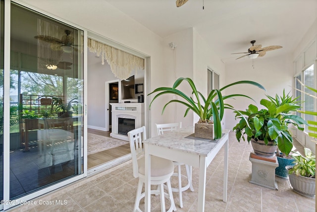 sunroom / solarium featuring ceiling fan