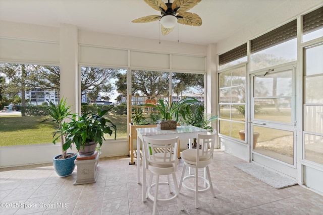 unfurnished sunroom featuring ceiling fan